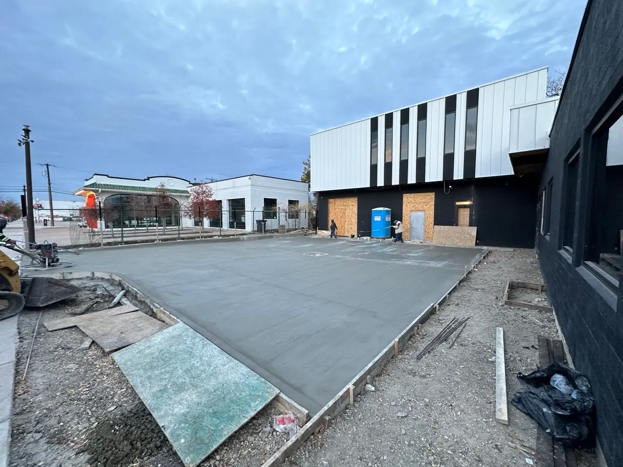 Fresh concrete for the parking lot, with the finished building behind it.