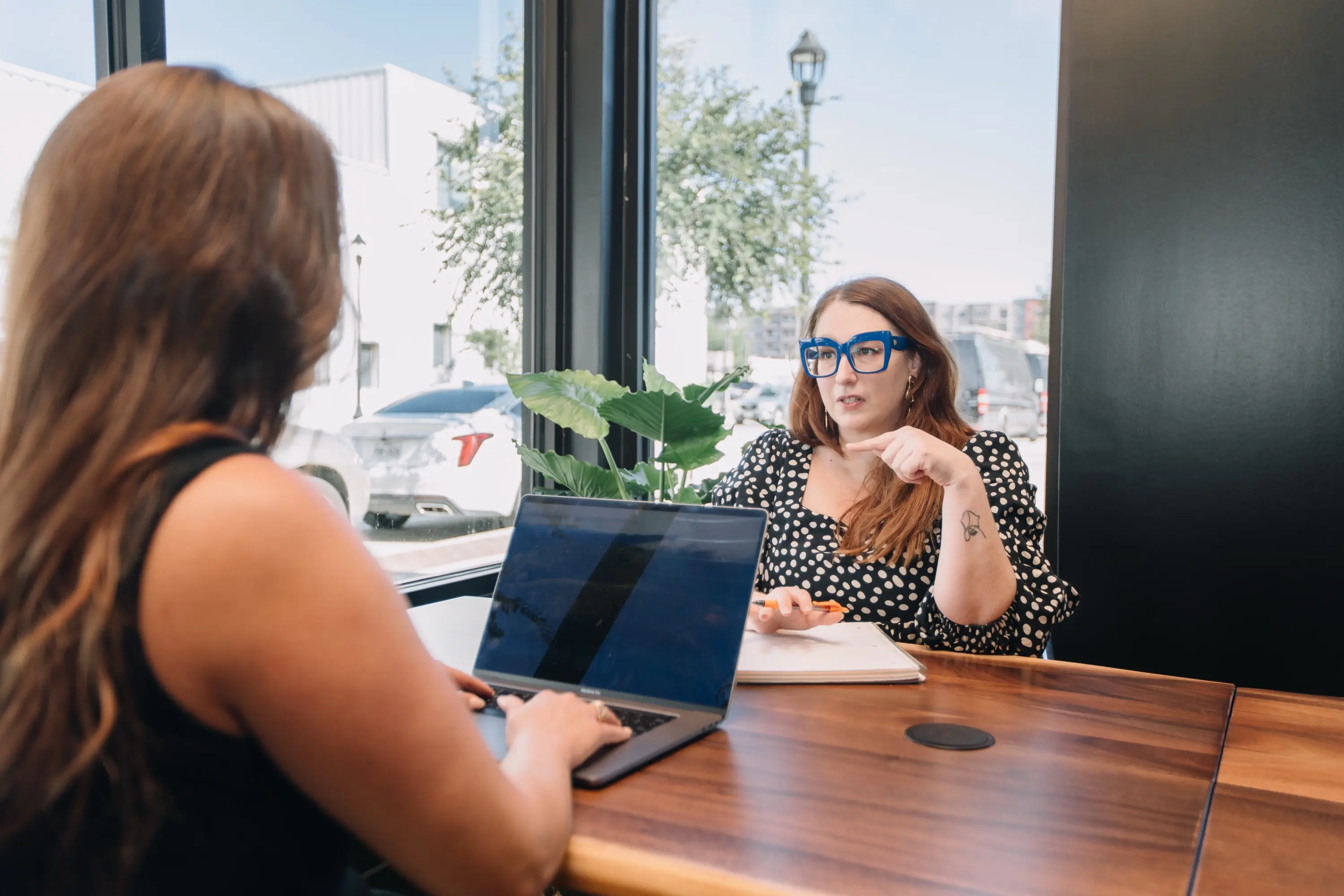 Two members working at a window table