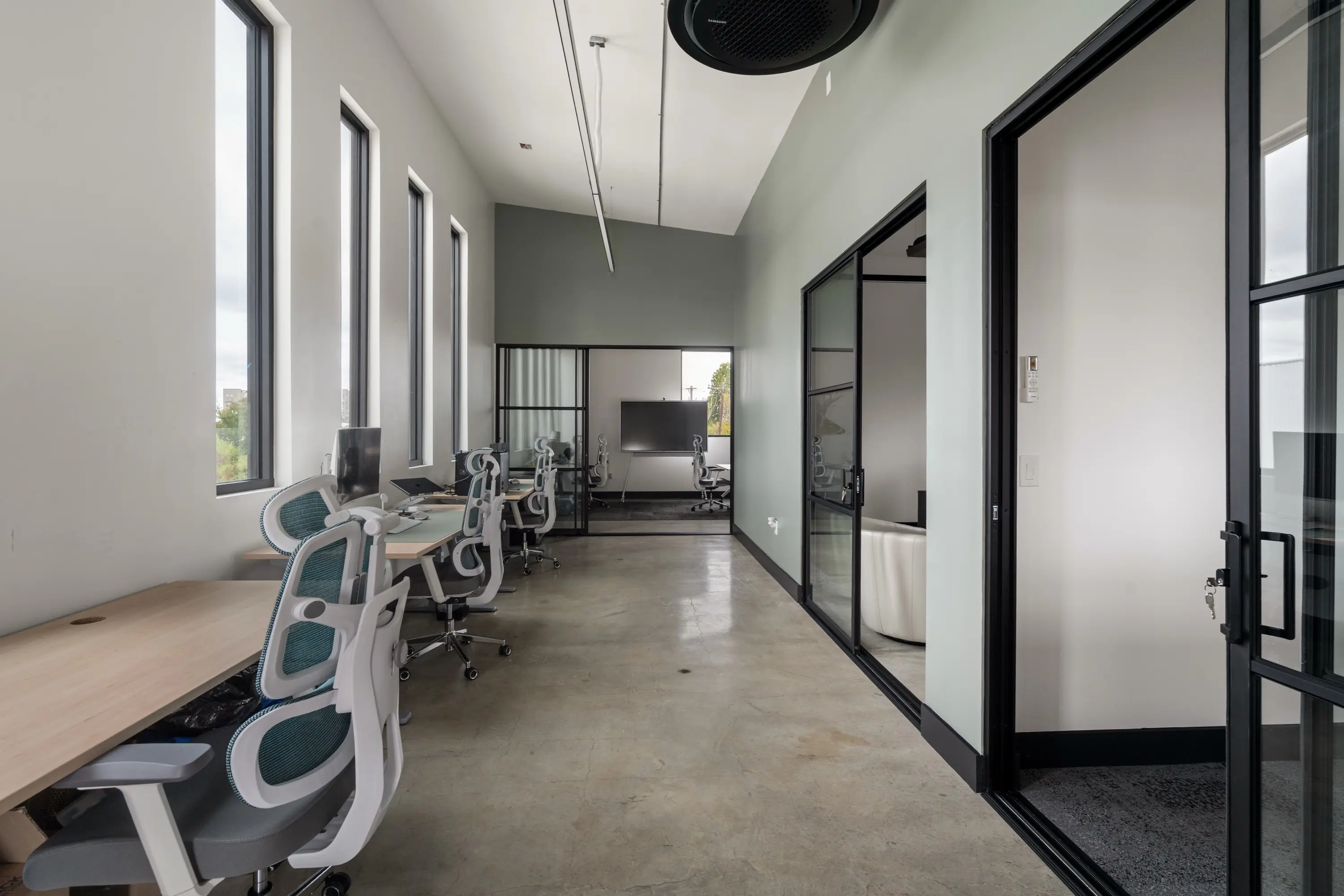 The second-floor fixed desk area, looking toward the glass offices