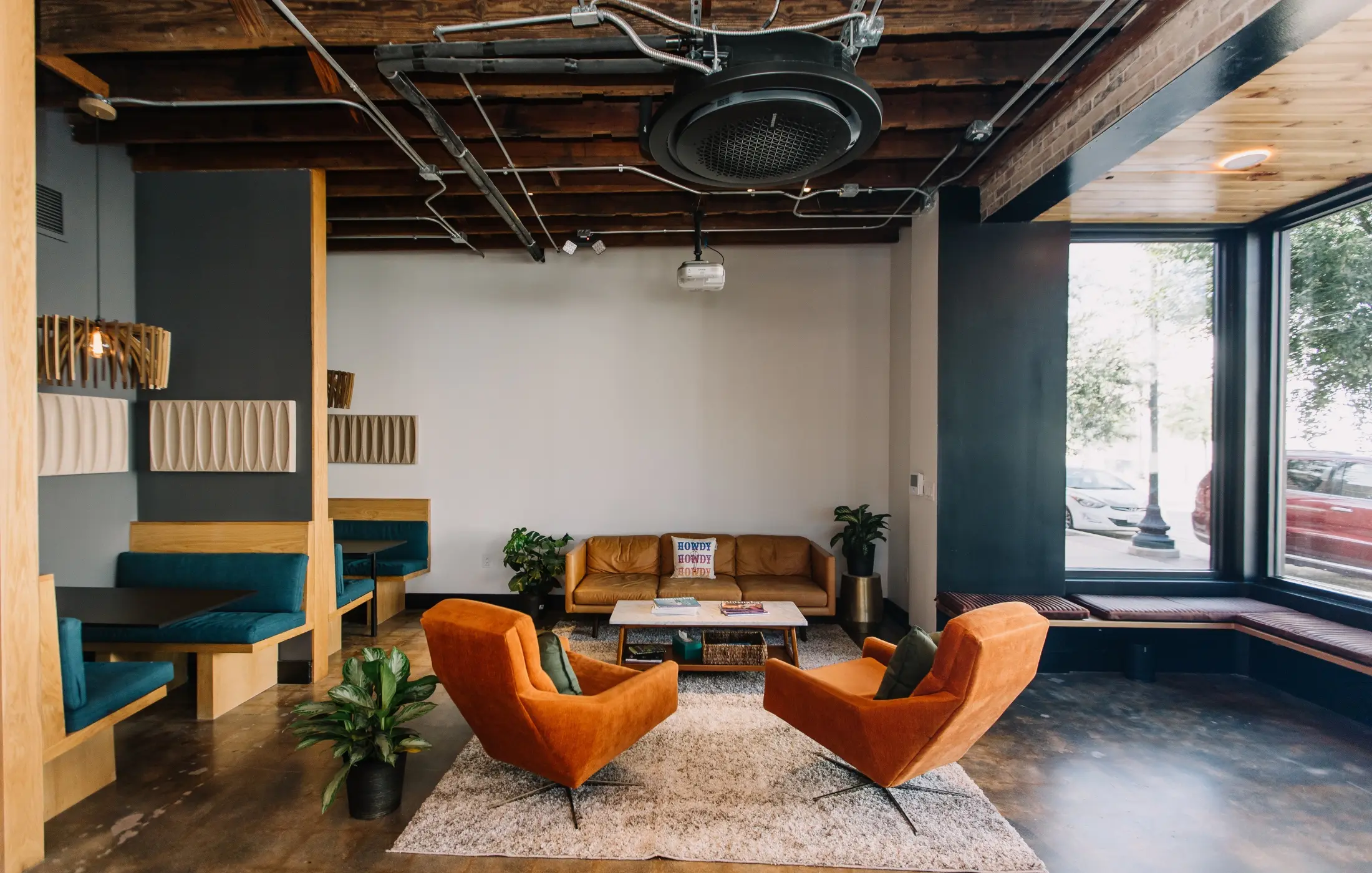 The SALT FW lounge with orange chairs, a sofa and window benches